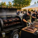 Offset smoker set up at a large outdoor catering event
