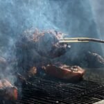 Meat smoking inside an offset smoker cooking chamber